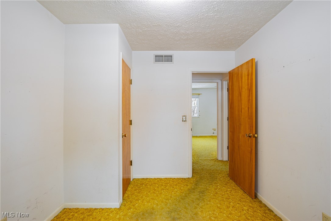 5905 Renninger Road New Franklin, OH 44319 - Photo 12 of 31 Corridor with a textured ceiling and light colored carpet