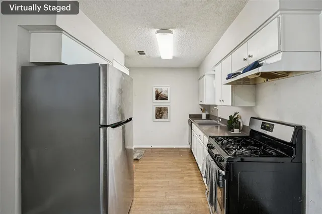 a kitchen with stainless steel appliances a refrigerator a stove and a sink