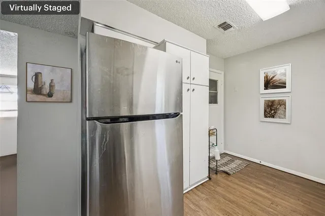 a view of a room with wooden floor and a ceiling fan