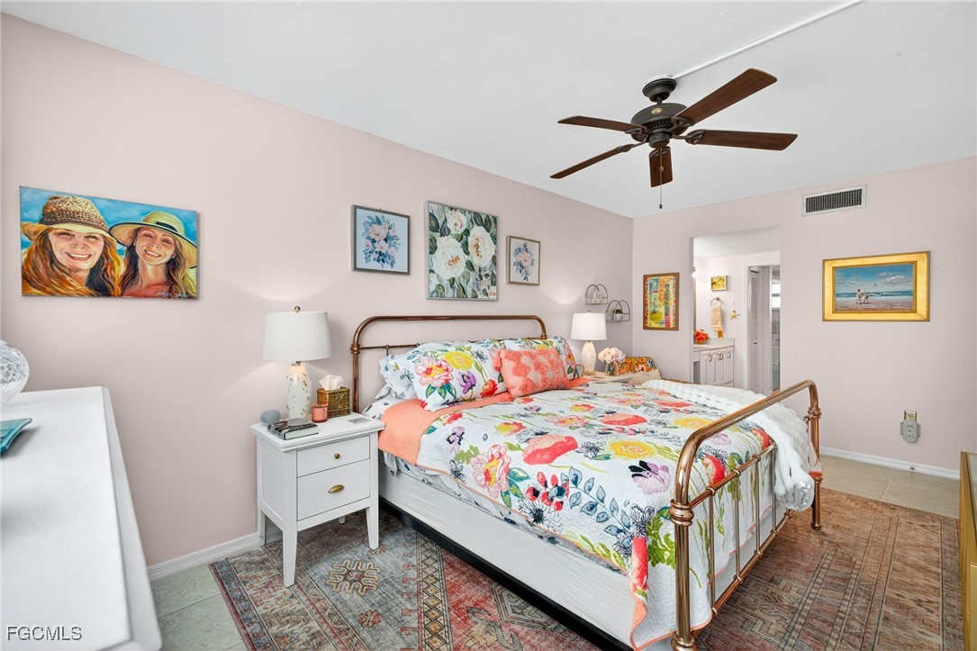801 River Point Drive, Unit 203A Naples, FL 34102 - Photo 15 of 32 a bedroom with a bed and a mirror