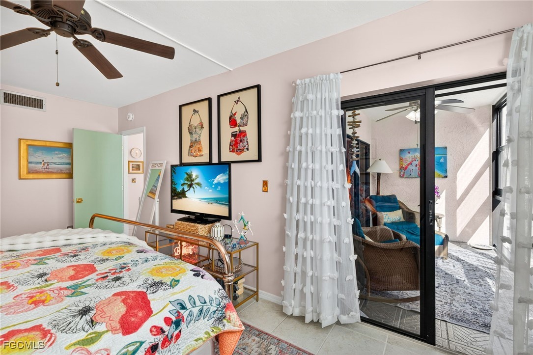 801 River Point Drive, Unit 203A Naples, FL 34102 - Photo 17 of 32 a bedroom with a bed and a flat screen tv