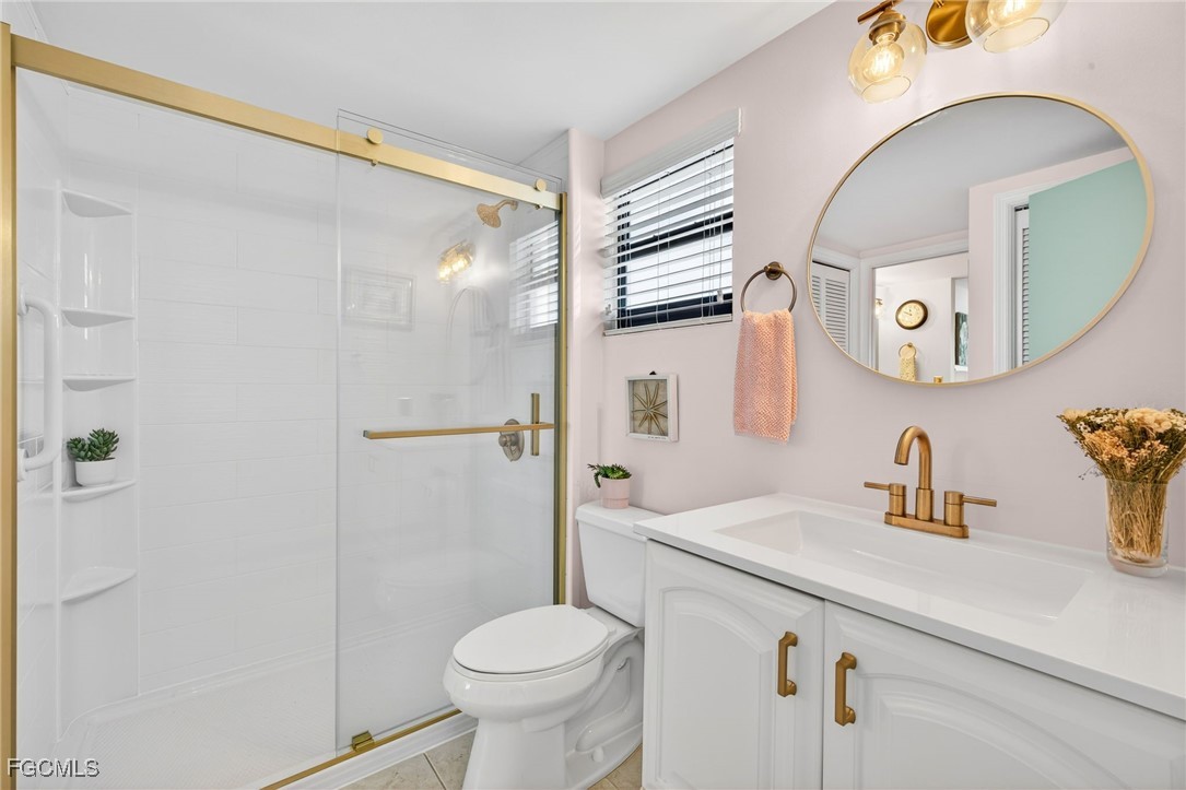801 River Point Drive, Unit 203A Naples, FL 34102 - Photo 20 of 32 a bathroom with a sink a toilet and a mirror