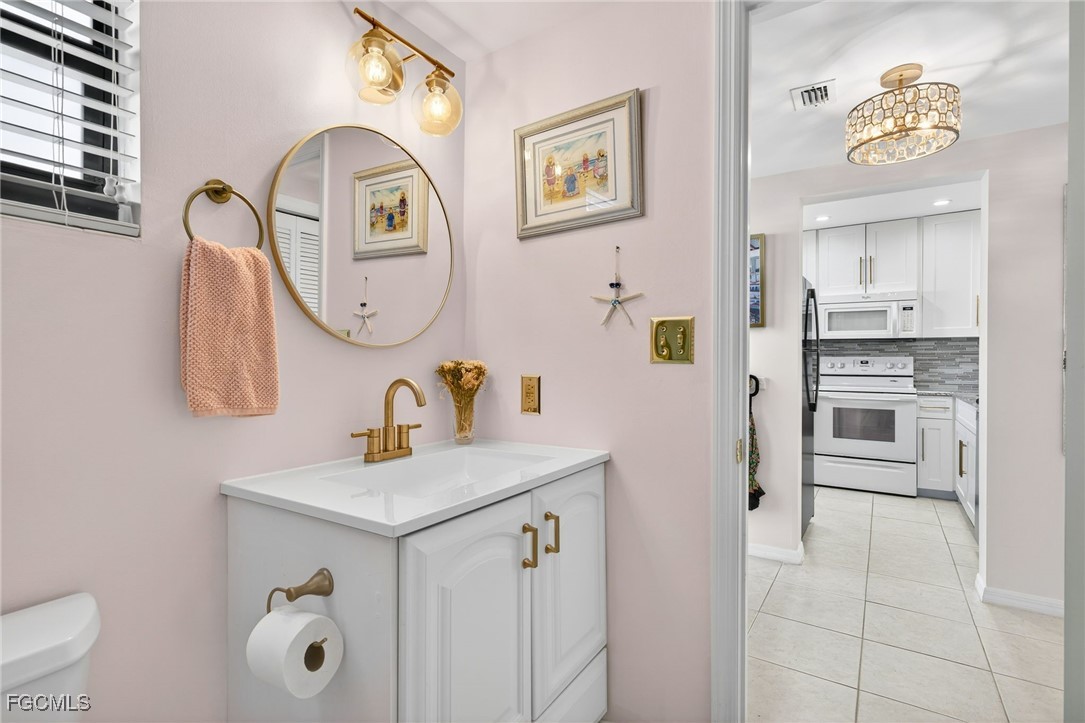 801 River Point Drive, Unit 203A Naples, FL 34102 - Photo 21 of 32 a bathroom with a sink mirror and toilet