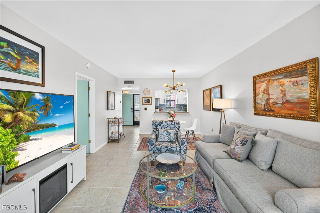 801 River Point Drive, Unit 203A Naples, FL 34102 - Photo 7 of 32 a living room with furniture and a flat screen tv