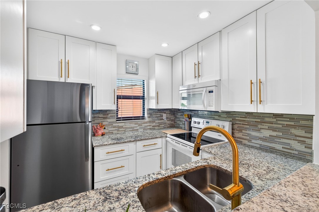 801 River Point Drive, Unit 203A Naples, FL 34102 - Photo 10 of 32 a kitchen with a refrigerator sink and stove