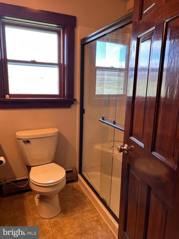 a bathroom with a tub shower and mirror