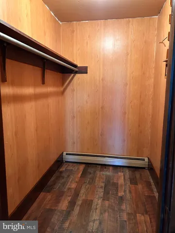 a view of an empty room with wooden floor and a fireplace