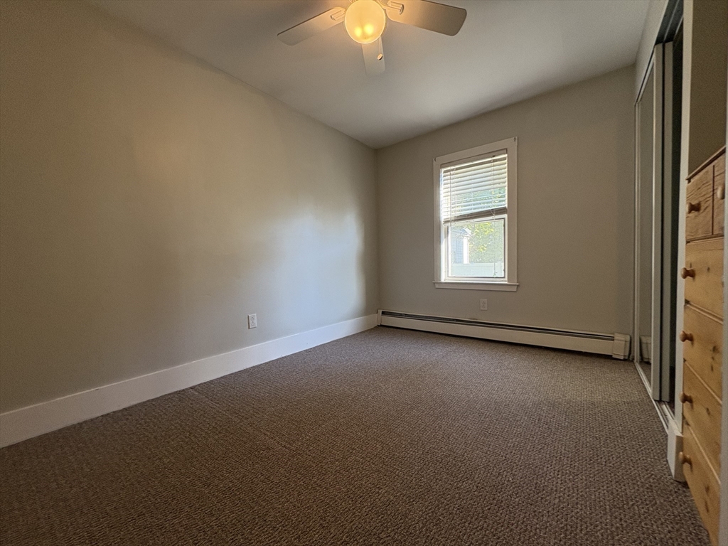 11 Franklin Street, Unit 1 Natick, MA 01760 - Photo 15 of 26 an empty room with a window and a fireplace