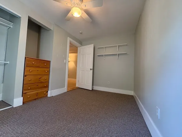 an empty room with closet and mirror