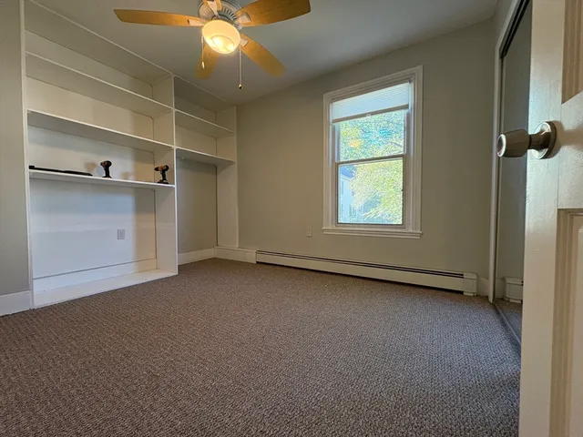 an empty room with windows and cabinet