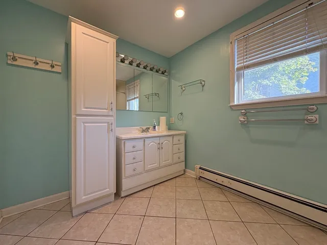 a room with a stove a sink and a window