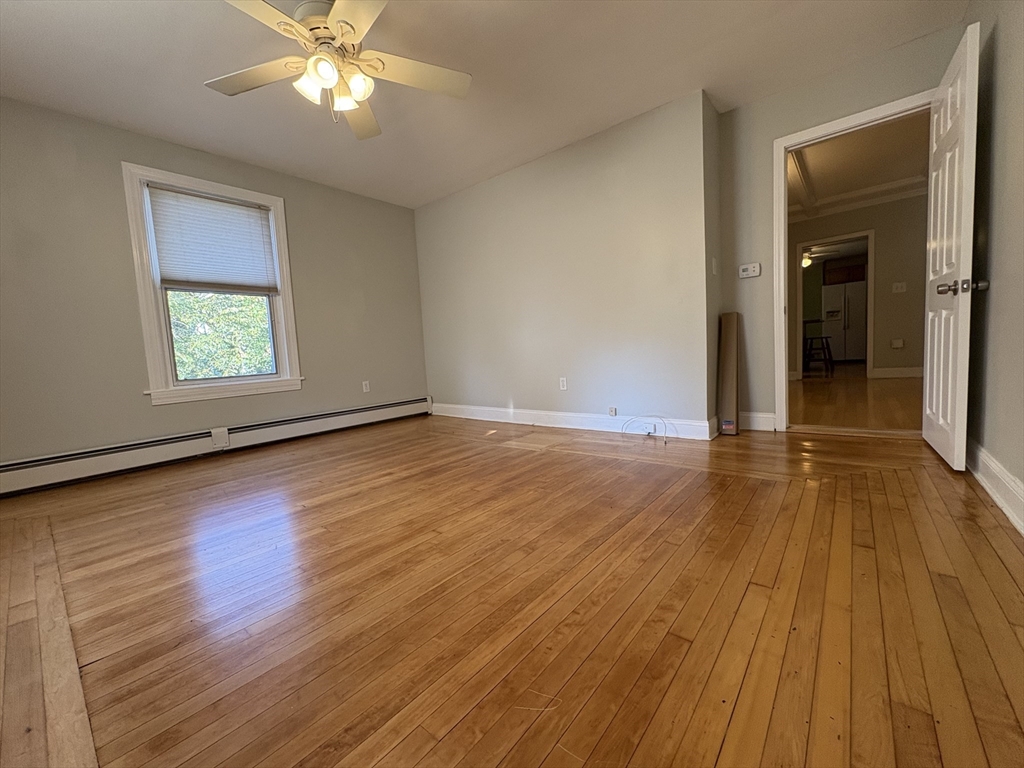 11 Franklin Street, Unit 1 Natick, MA 01760 - Photo 4 of 26 an empty room with wooden floor and windows