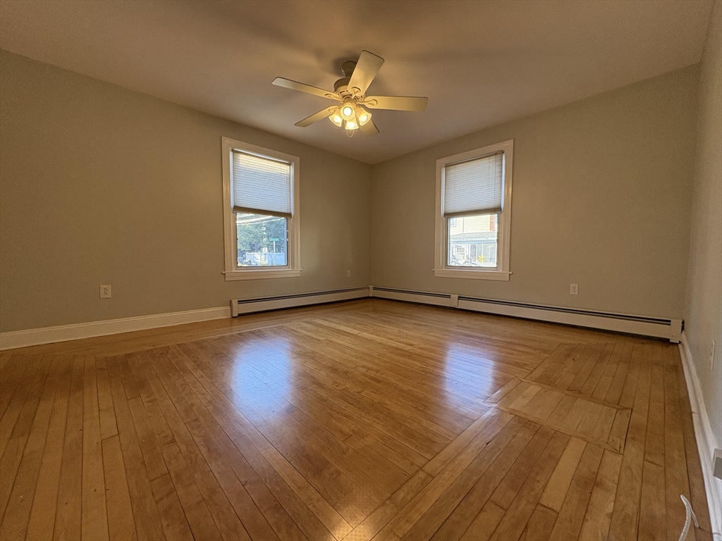 11 Franklin Street, Unit 1 Natick, MA 01760 - Photo 5 of 26 a view of an empty room with wooden floor and a window
