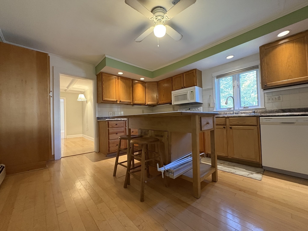 11 Franklin Street, Unit 1 Natick, MA 01760 - Photo 7 of 26 a kitchen with stainless steel appliances granite countertop a sink cabinets and wooden floor