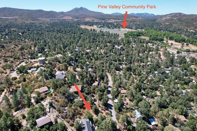 an aerial view of residential house with outdoor space and trees all around