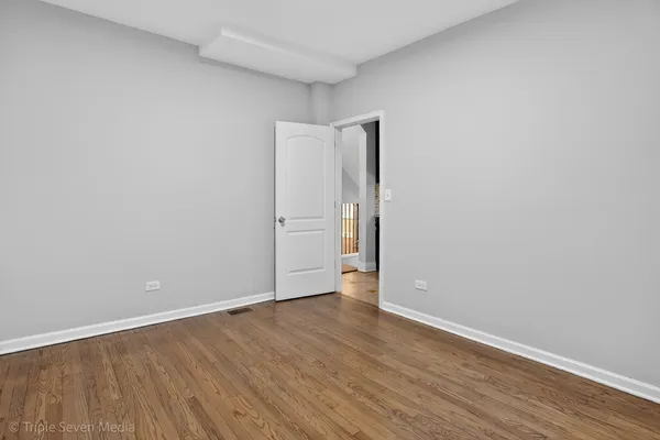 a view of an empty room with wooden floor