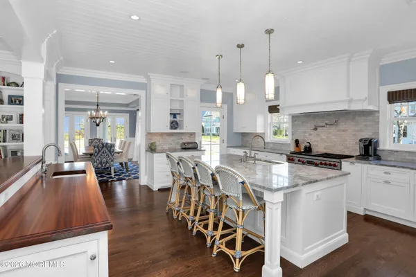 a large kitchen with kitchen island a large counter space a sink appliances and a living room view