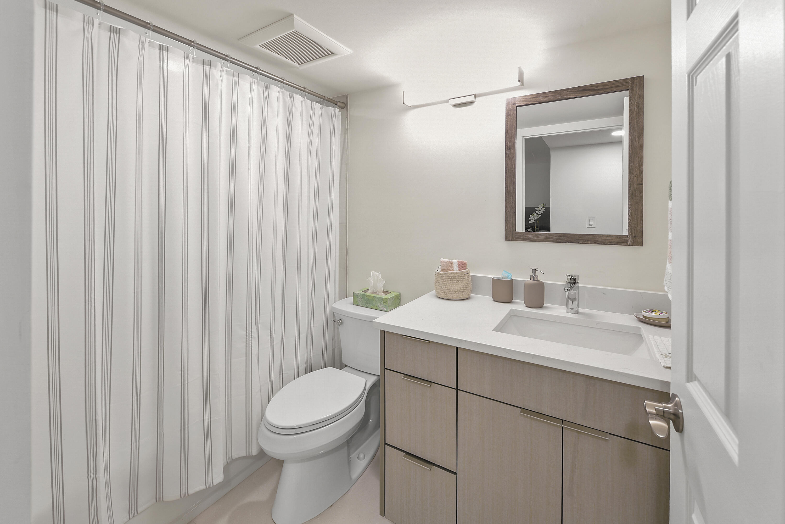 7145 Promenade Drive, Unit 101 Boca Raton, FL 33433 - Photo 12 of 24 a bathroom with a toilet a sink a vanity and mirror