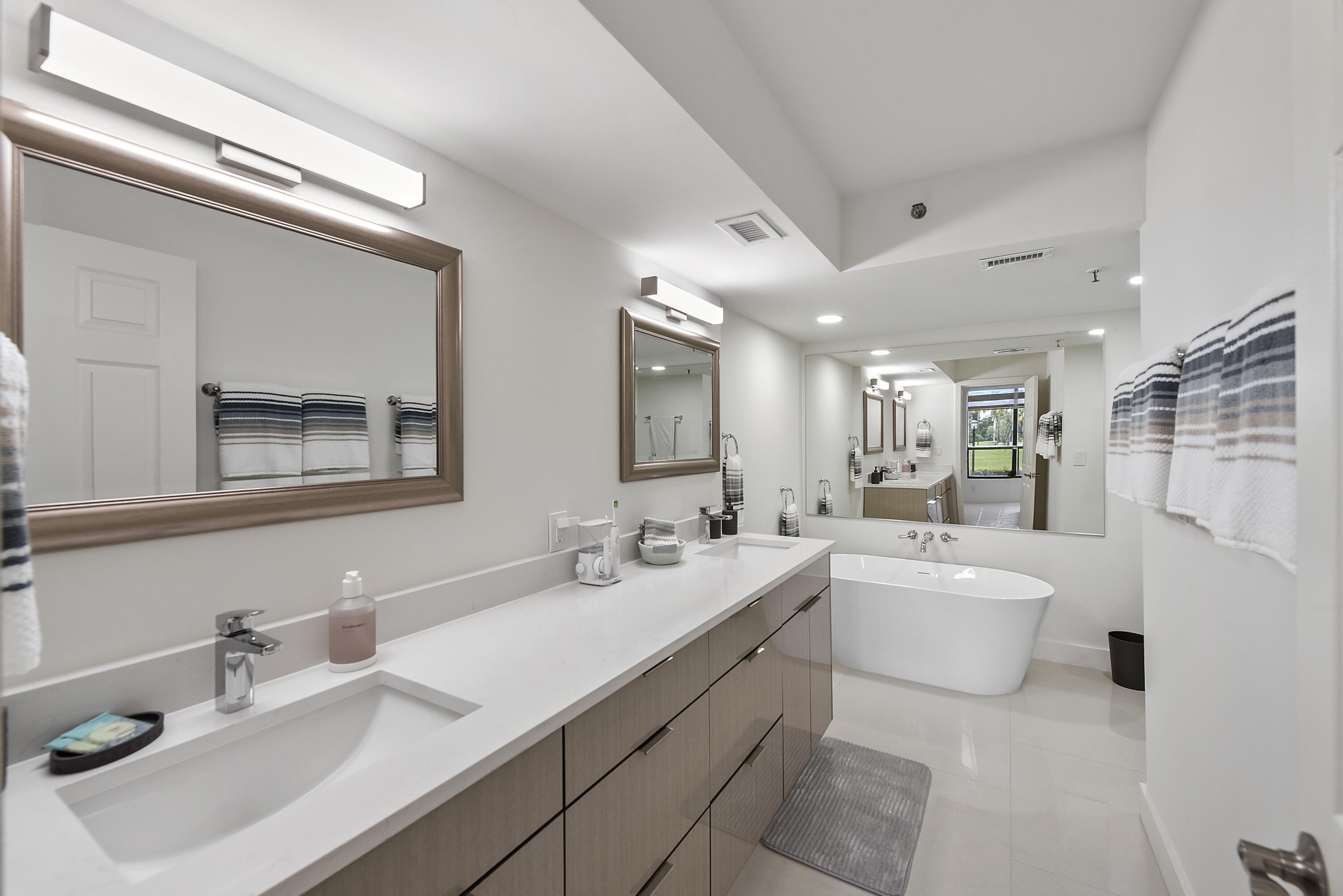 7145 Promenade Drive, Unit 101 Boca Raton, FL 33433 - Photo 8 of 24 a bathroom with a sink double vanity mirror and a bathtub