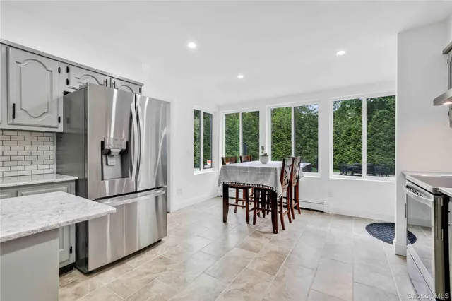 a kitchen with stainless steel appliances granite countertop a refrigerator and a table