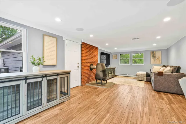 a living room with furniture a dining table wooden floor and a large window