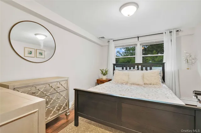 a bedroom with a bed and a large mirror on the dresser