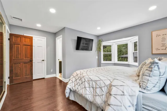 a spacious bedroom with a large bed and wooden floor