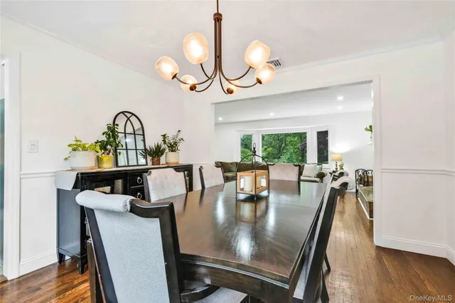 a view of a dining room with furniture a chandelier and wooden floor