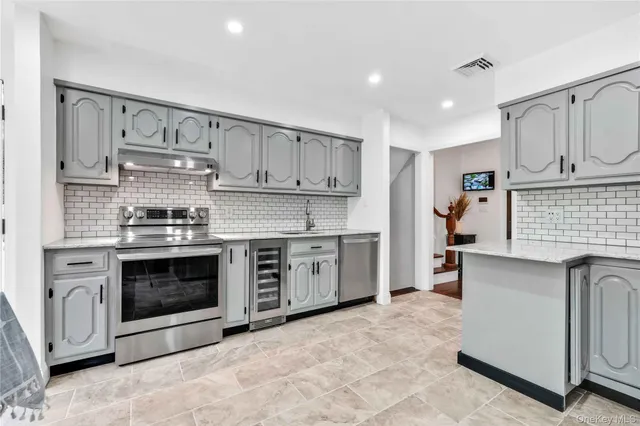 a kitchen with stainless steel appliances granite countertop a stove and white cabinets