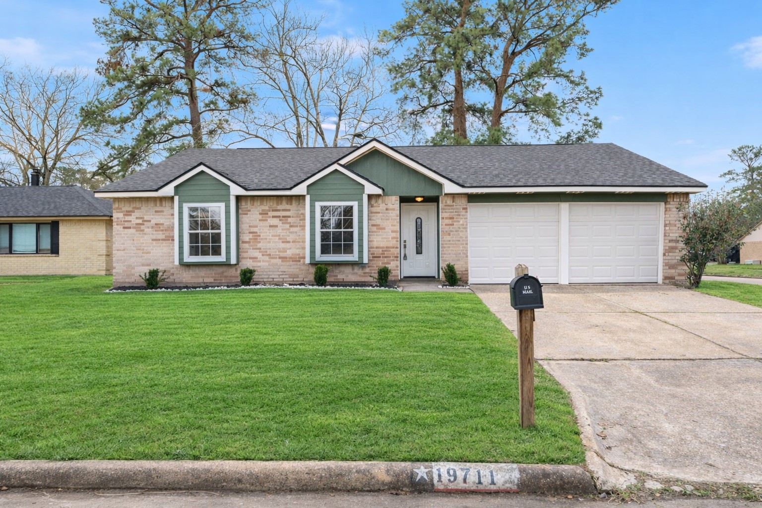 Clean curb appeal with fresh landscaping, a two-car garage, and a welcoming entry.