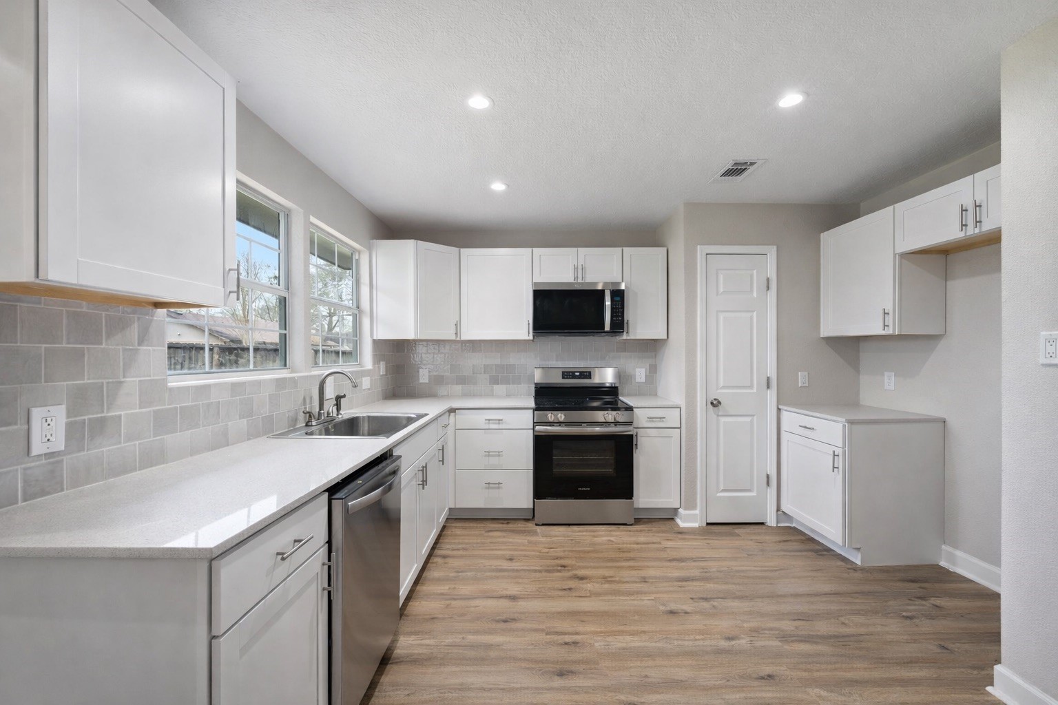 19711 Bishops Gate Lane Humble, TX 77338 - Photo 5 of 12 Updated kitchen with white cabinetry, stainless steel appliances, and great counter space.