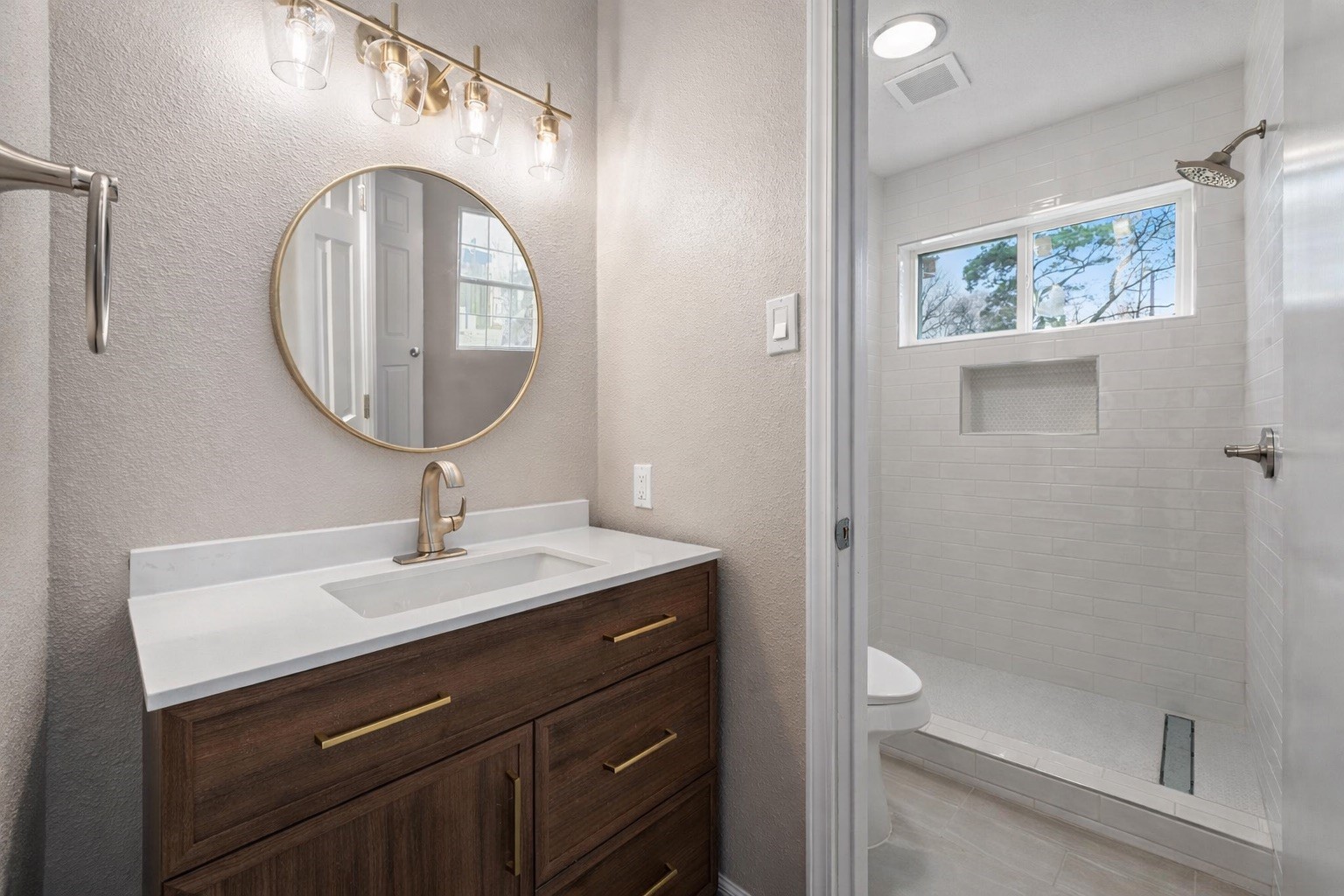 19711 Bishops Gate Lane Humble, TX 77338 - Photo 7 of 12 Updated primary bath with a modern vanity, warm brass accents, and a fully tiled walk-in shower that keeps the space feeling clean and refined.