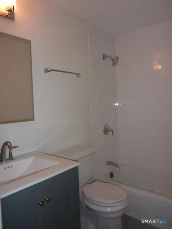 a bathroom with a granite countertop sink toilet and a mirror