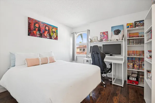 a bedroom with a bed and a bookshelf with wooden floor