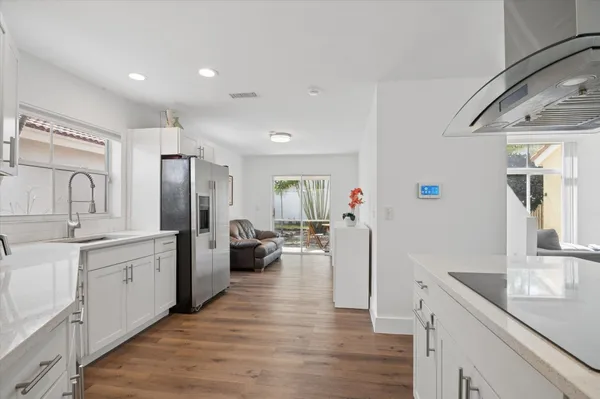 a large kitchen with a lot of counter space and wooden floor