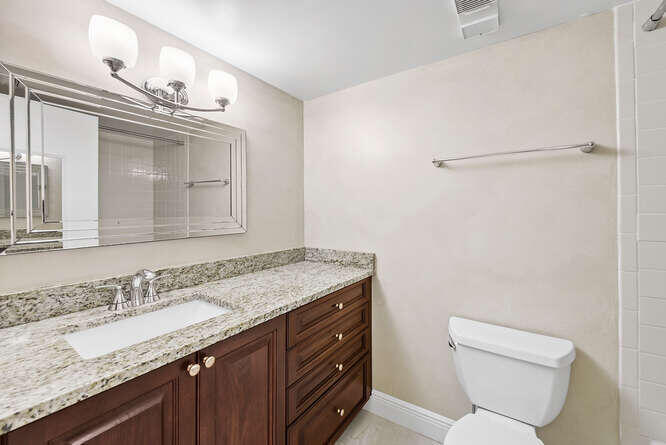 Undisclosed Address Stuart, FL 34994 - Photo 13 of 41 a bathroom with a granite countertop sink a toilet and a mirror