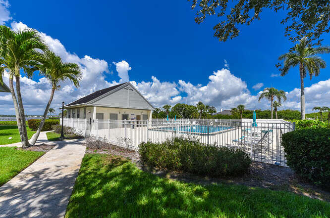 Undisclosed Address Stuart, FL 34994 - Photo 28 of 41 a front view of a house with a yard and potted plants