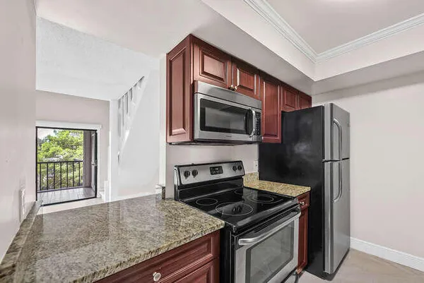 a bathroom with a granite countertop sink toilet and mirror