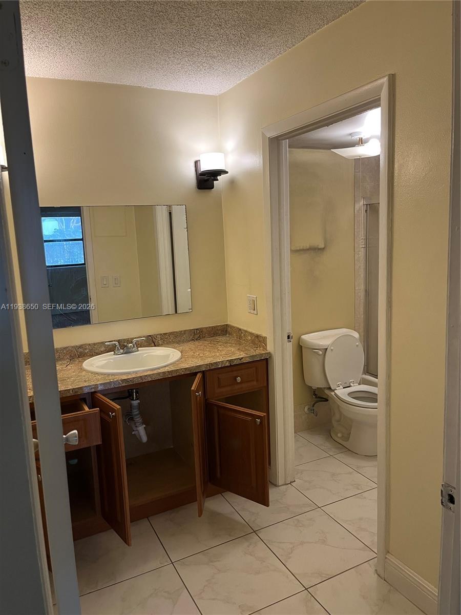 15630 Southwest 80th Street, Unit I110 Miami, FL 33193 - Photo 12 of 28 a bathroom with a sink a toilet and a mirror
