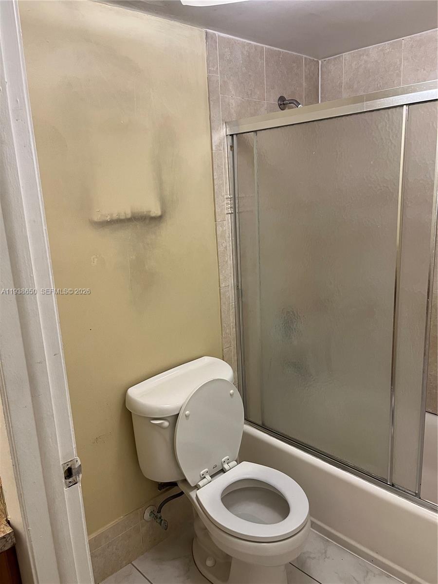 15630 Southwest 80th Street, Unit I110 Miami, FL 33193 - Photo 13 of 28 a white toilet sitting next to a shower