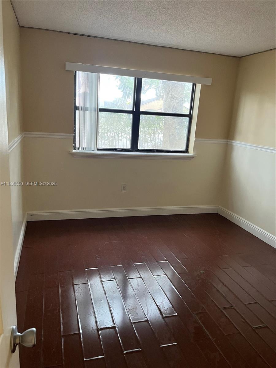 15630 Southwest 80th Street, Unit I110 Miami, FL 33193 - Photo 10 of 28 an empty room with wooden floor and windows