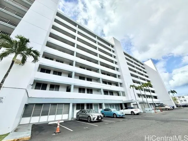 a front view of a building with streets and trees
