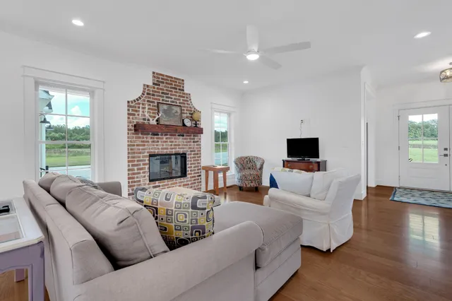 a living room with furniture a flat screen tv and a large window