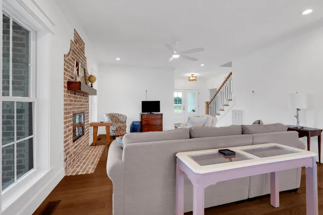 a kitchen with stainless steel appliances granite countertop a sink a refrigerator a center island a stove and a wooden floors