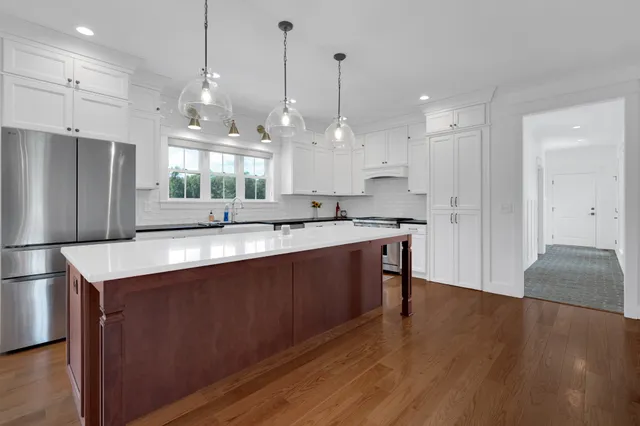 a kitchen with stainless steel appliances sink stove and wooden cabinets