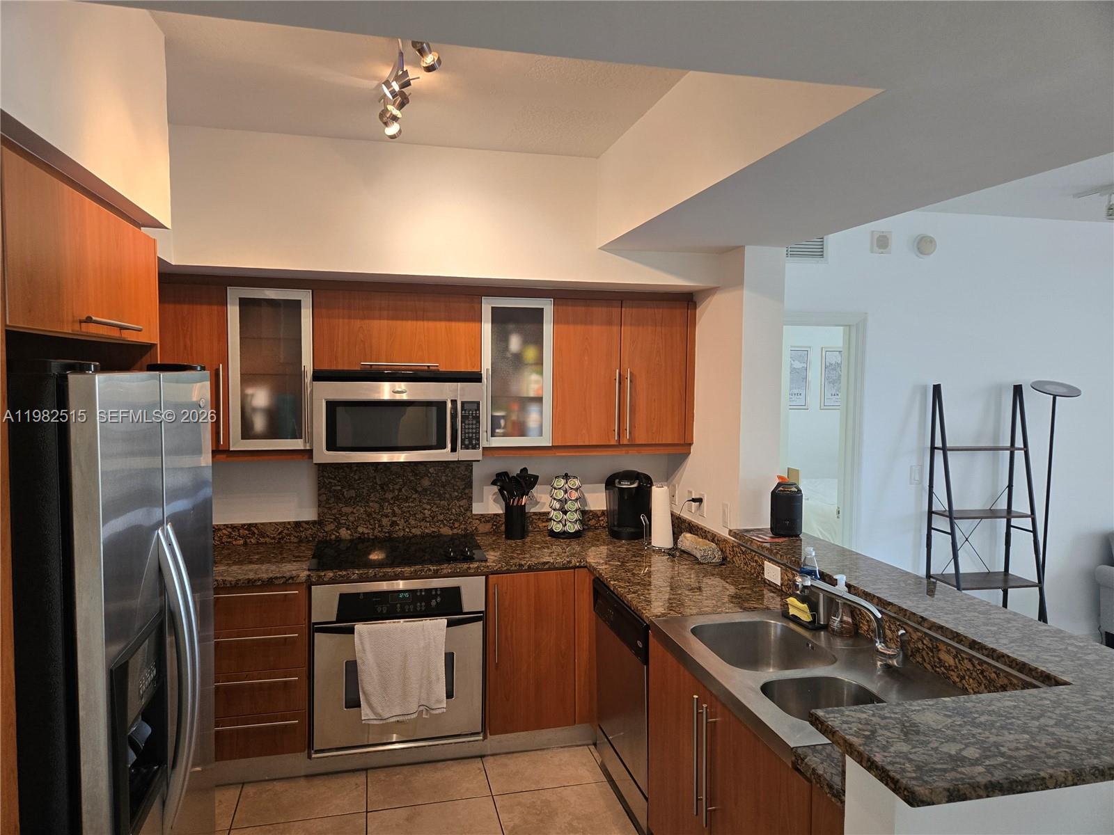 888 Douglas Road, Unit 405 Coral Gables, FL 33134 - Photo 2 of 24 a kitchen with stainless steel appliances granite countertop a sink stove microwave and refrigerator