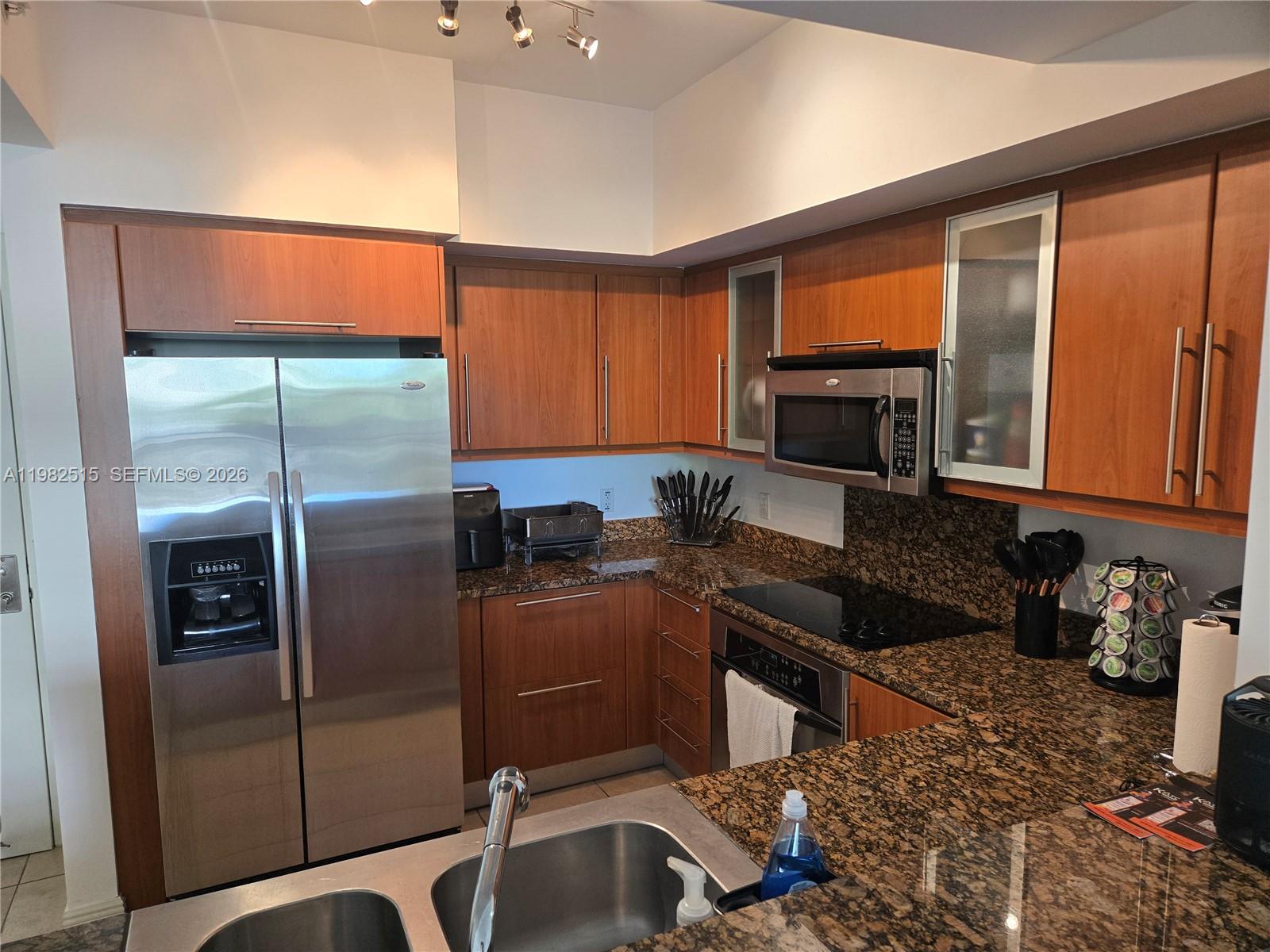 888 Douglas Road, Unit 405 Coral Gables, FL 33134 - Photo 3 of 24 a kitchen with a refrigerator a sink a stove and cabinets
