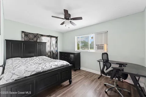 a bedroom with a bed and wooden floor