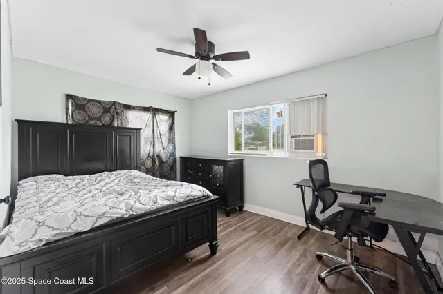 a bedroom with a bed and wooden floor