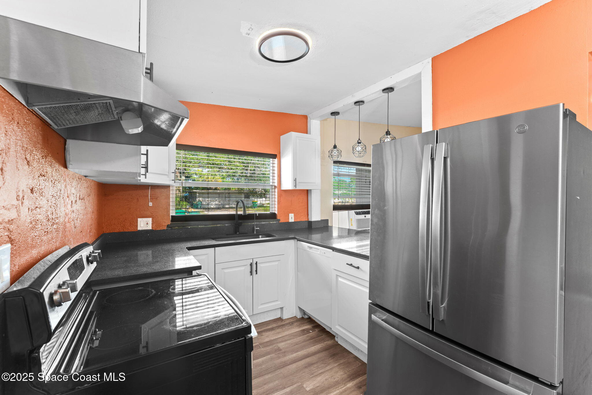 406 North Fiske Boulevard Cocoa, FL 32922 - Photo 6 of 21 a kitchen with stainless steel appliances granite countertop a refrigerator a sink and white cabinets